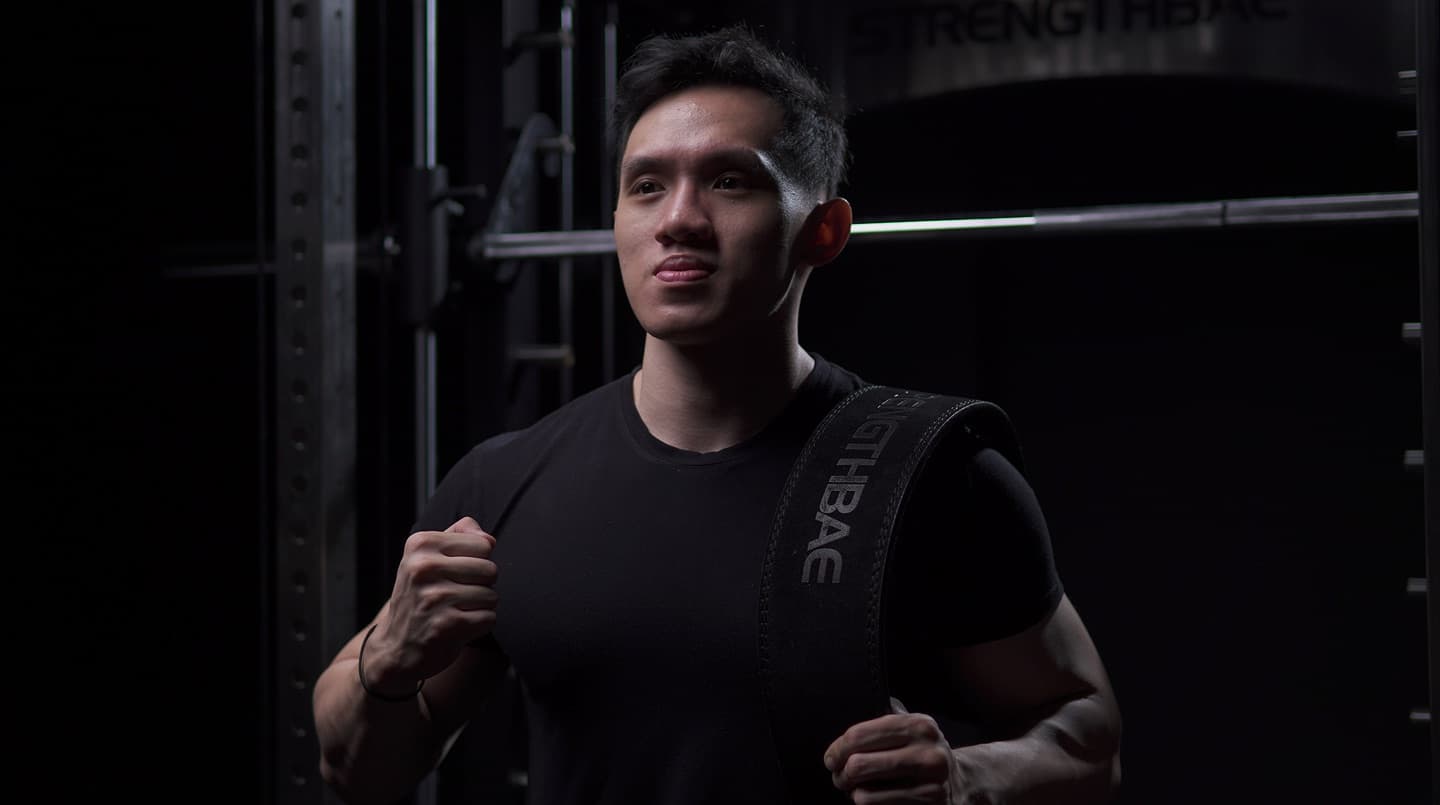 Atlet membawa strap Strengthbae di gym yang gelap