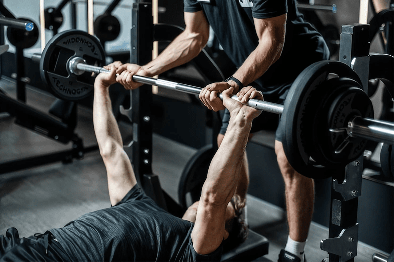 Atlet melakukan bench press dengan barbel bermuatan berat